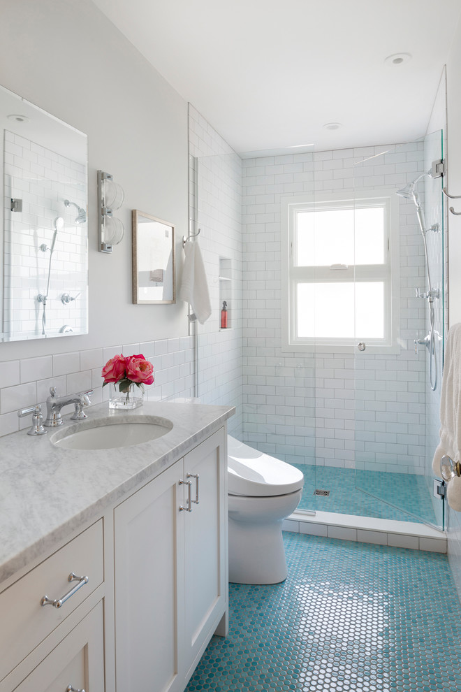 На фото: детская ванная комната в стиле фьюжн с плоскими фасадами, белыми фасадами, душем в нише, унитазом-моноблоком, белой плиткой, плиткой кабанчик, белыми стенами, полом из мозаичной плитки, врезной раковиной, мраморной столешницей, синим полом, душем с распашными дверями и серой столешницей с