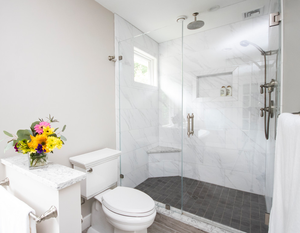 Inspiration for a large classic ensuite bathroom in Providence with recessed-panel cabinets, white cabinets, a freestanding bath, a built-in shower, a two-piece toilet, white tiles, marble tiles, grey walls, ceramic flooring, a submerged sink, quartz worktops, grey floors, a hinged door and grey worktops.