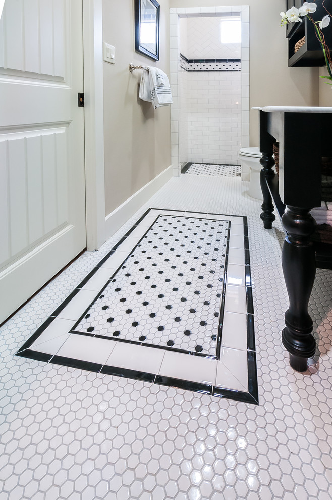 Klassisk inredning av ett mellanstort en-suite badrum, med ett konsol handfat, släta luckor, svarta skåp, marmorbänkskiva, en öppen dusch, en toalettstol med hel cisternkåpa, vit kakel, keramikplattor, grå väggar, klinkergolv i keramik och vitt golv
