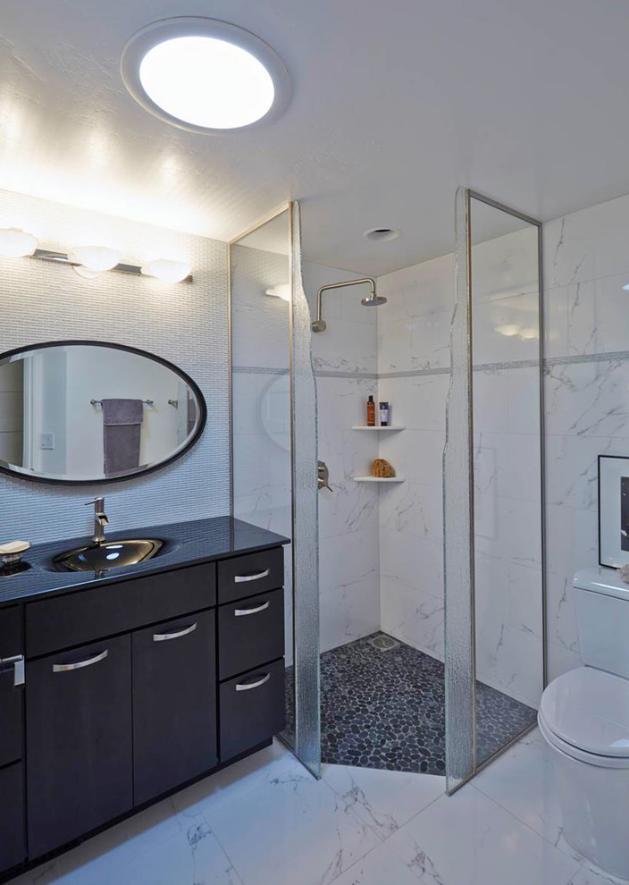 Small 1950s 3/4 white tile and stone tile marble floor corner shower photo in San Francisco with a console sink, flat-panel cabinets, black cabinets, solid surface countertops, a one-piece toilet and white walls