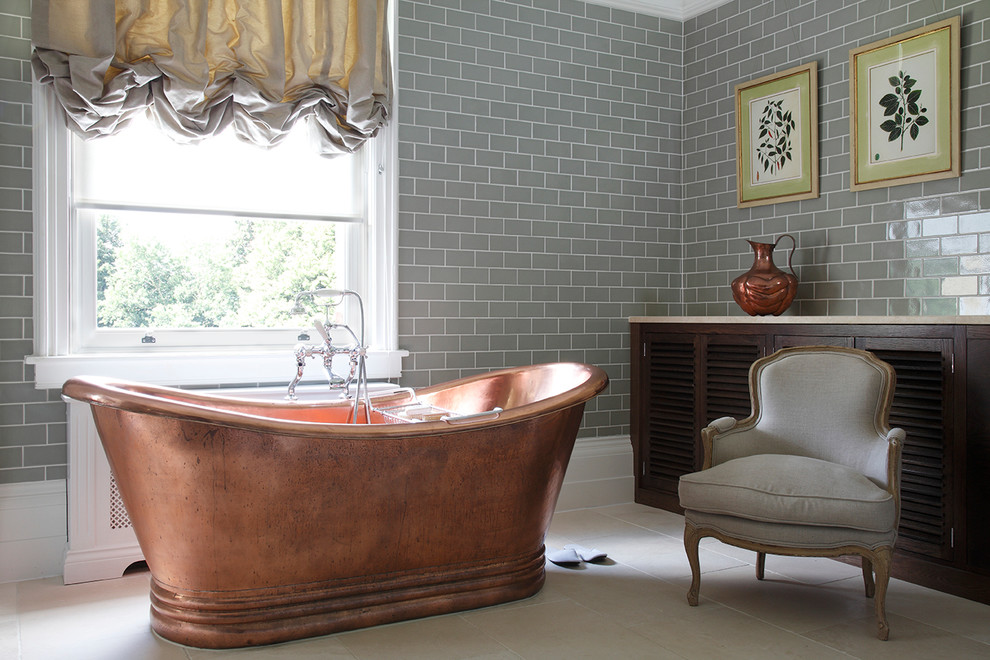 Пример оригинального дизайна: ванная комната в стиле шебби-шик с отдельно стоящей ванной, зелеными стенами и полом из известняка