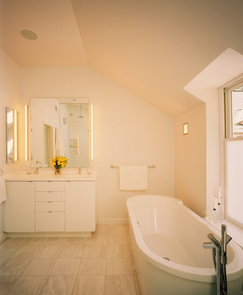 Diseño de cuarto de baño actual con armarios con paneles lisos, puertas de armario blancas y bañera exenta