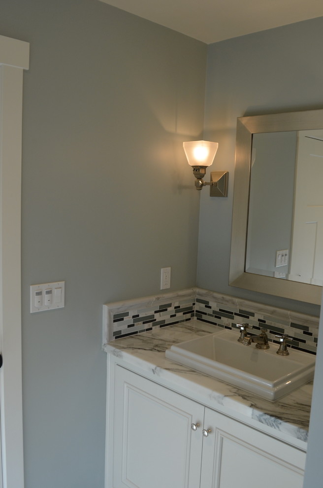 Inspiration för klassiska badrum, med ett nedsänkt handfat, luckor med infälld panel, vita skåp, marmorbänkskiva och grå kakel