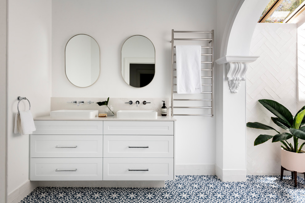 Klassisk inredning av ett mellanstort vit vitt en-suite badrum, med vita skåp, vit kakel, tunnelbanekakel, vita väggar, klinkergolv i porslin, bänkskiva i kvarts, blått golv, skåp i shakerstil och ett fristående handfat
