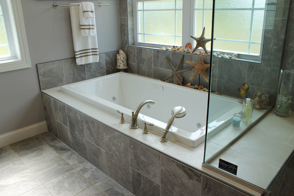 Immagine di una grande stanza da bagno padronale tradizionale con vasca da incasso, doccia ad angolo, pareti grigie, piastrelle grigie, piastrelle in gres porcellanato e pavimento in gres porcellanato