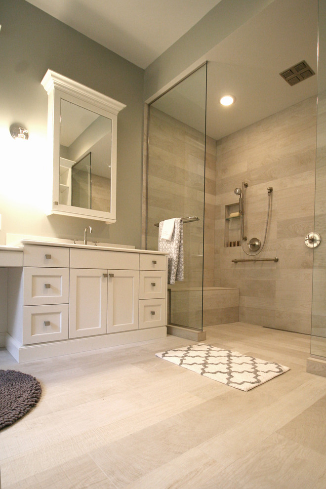 Exempel på ett mycket stort klassiskt en-suite badrum, med ett undermonterad handfat, vita skåp, en dubbeldusch, en bidé, grå kakel, porslinskakel, grå väggar, luckor med infälld panel, bänkskiva i akrylsten och klinkergolv i porslin