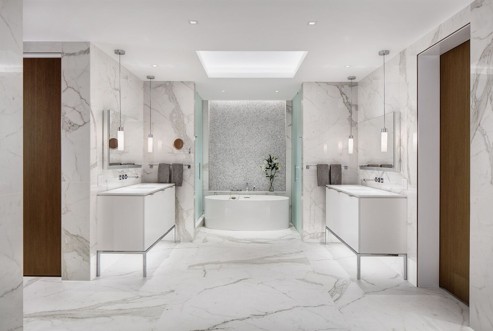 На фото: главная ванная комната среднего размера в современном стиле с плоскими фасадами, белыми фасадами, отдельно стоящей ванной, душем в нише, белой плиткой, мраморной плиткой, белыми стенами, мраморным полом, врезной раковиной и душем с распашными дверями