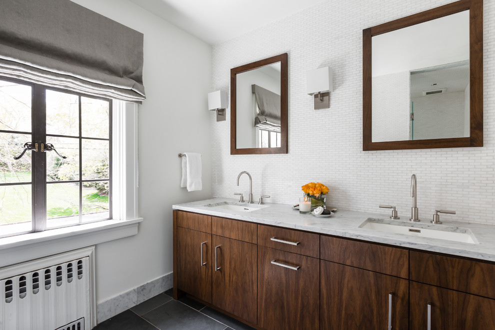 Idées déco pour une salle de bain principale moderne en bois foncé avec un lavabo encastré, un placard à porte plane, un plan de toilette en marbre, un carrelage blanc et un mur blanc.