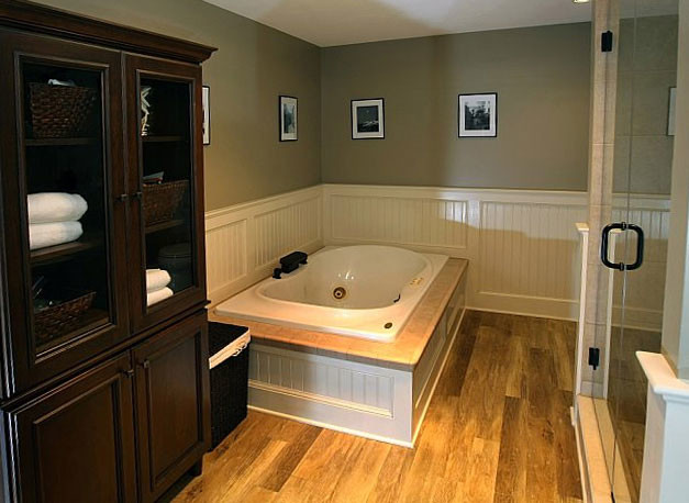 Пример оригинального дизайна: огромная главная ванная комната в классическом стиле с врезной раковиной, фасадами островного типа, темными деревянными фасадами, мраморной столешницей, гидромассажной ванной, двойным душем, раздельным унитазом, бежевой плиткой, керамогранитной плиткой, коричневыми стенами и паркетным полом среднего тона