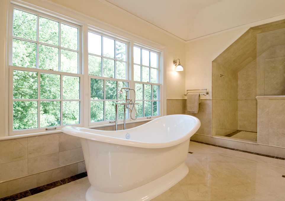 Photo of a traditional bathroom in Boston with a freestanding bath, beige tiles and stone tiles.