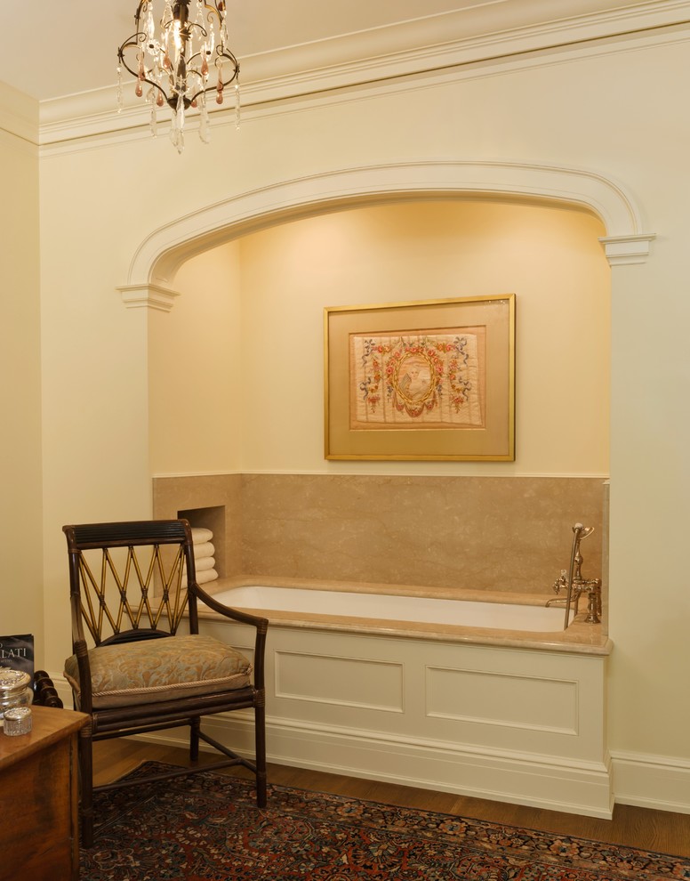 Exemple d'une salle de bain principale chic de taille moyenne avec un placard avec porte à panneau encastré, des portes de placard blanches, un plan de toilette en marbre, une baignoire encastrée, un carrelage beige, des dalles de pierre et un sol en bois brun.