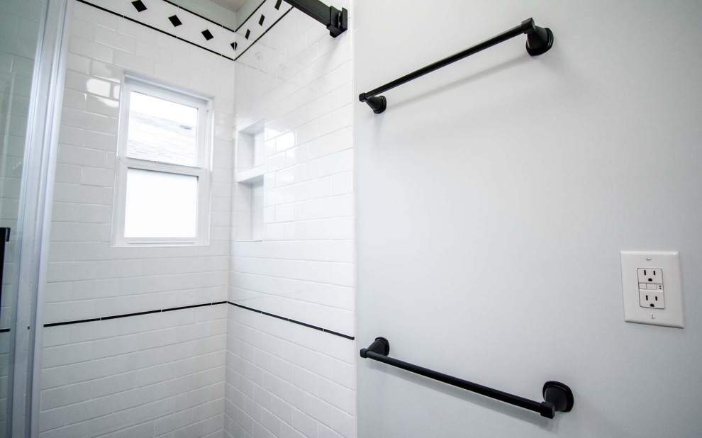 Inspiration for a small traditional shower room bathroom in Portland with shaker cabinets, white cabinets, an alcove shower, a two-piece toilet, white tiles, metro tiles, white walls, ceramic flooring, a submerged sink, engineered stone worktops, white floors, a sliding door, black worktops, a wall niche, a single sink and a freestanding vanity unit.
