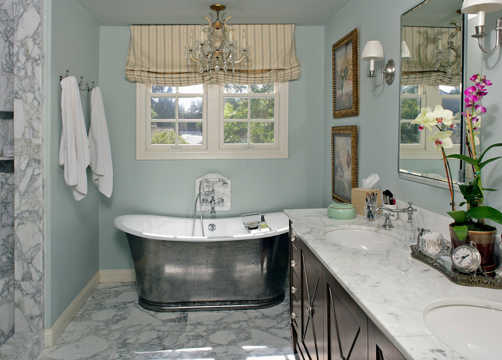 Idée de décoration pour une petite salle de bain principale tradition en bois foncé avec un lavabo encastré, un placard en trompe-l'oeil, un plan de toilette en marbre, une baignoire indépendante, une douche ouverte, des dalles de pierre, un mur bleu et un sol en marbre.