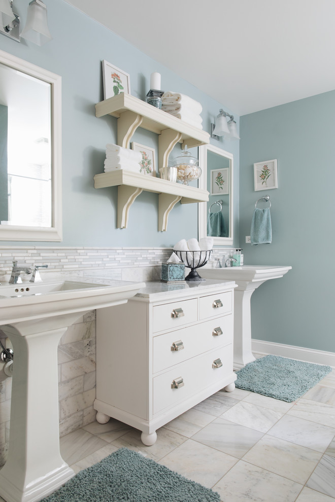 Modelo de cuarto de baño clásico renovado con armarios con paneles lisos, puertas de armario blancas, baldosas y/o azulejos blancos, paredes azules, lavabo con pedestal, suelo blanco y encimeras blancas