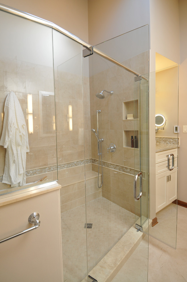 Inredning av ett klassiskt mellanstort en-suite badrum, med ett undermonterad handfat, luckor med infälld panel, vita skåp, granitbänkskiva, ett badkar i en alkov, en dusch/badkar-kombination, en toalettstol med separat cisternkåpa, flerfärgad kakel, porslinskakel, beige väggar och klinkergolv i porslin