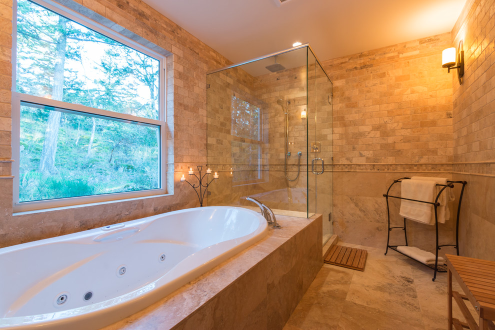 This is an example of a large traditional ensuite bathroom in Vancouver with a built-in bath, an alcove shower, multi-coloured tiles, stone tiles and travertine flooring.