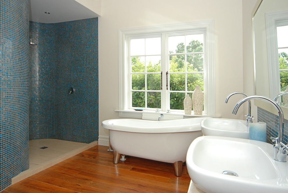 Bathroom - mid-sized contemporary master blue tile and mosaic tile medium tone wood floor bathroom idea in Auckland with a vessel sink