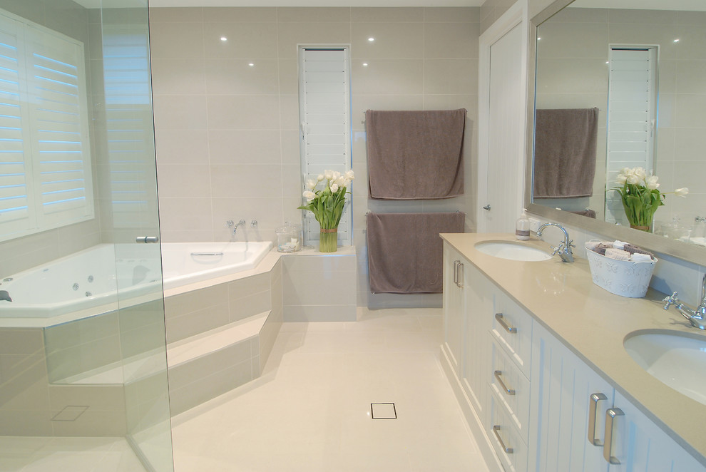 Ejemplo de cuarto de baño principal clásico grande con bañera esquinera y baldosas y/o azulejos beige