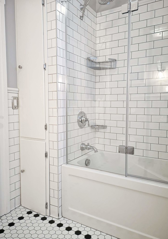 Bild på ett mellanstort vintage grå grått badrum med dusch, med ett badkar i en alkov, en dusch/badkar-kombination, en toalettstol med separat cisternkåpa, vit kakel, tunnelbanekakel, grå väggar, klinkergolv i porslin, ett konsol handfat, vitt golv och dusch med gångjärnsdörr