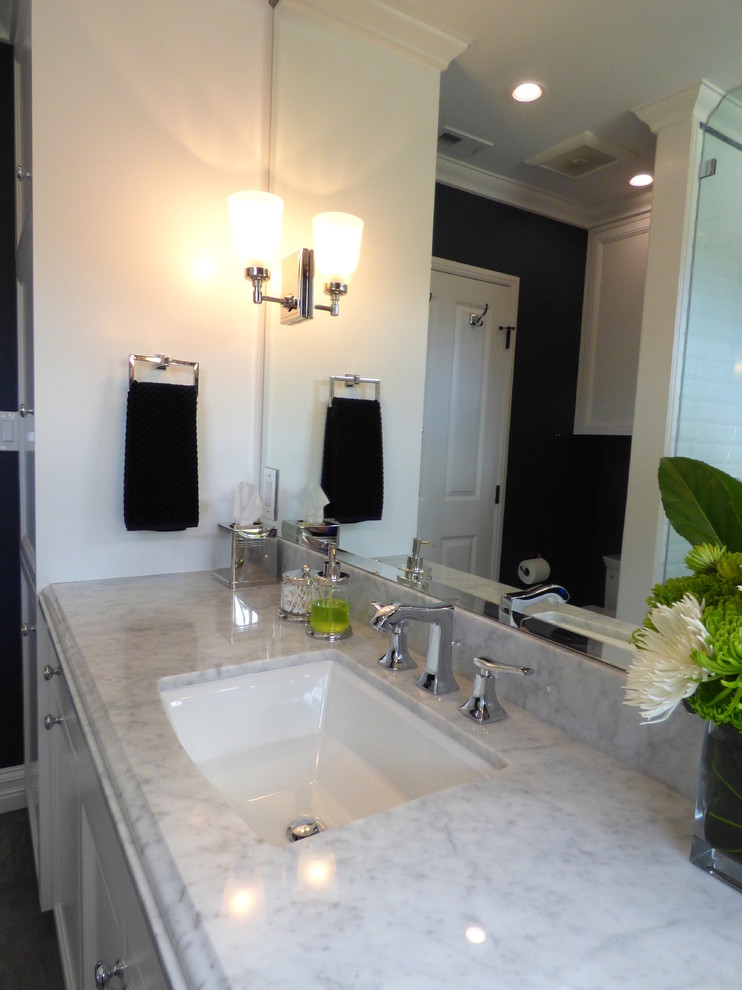 Photo of a small classic shower room bathroom in Los Angeles with a submerged sink, flat-panel cabinets, white cabinets, marble worktops, an alcove shower, a one-piece toilet, white tiles, metro tiles, blue walls and porcelain flooring.