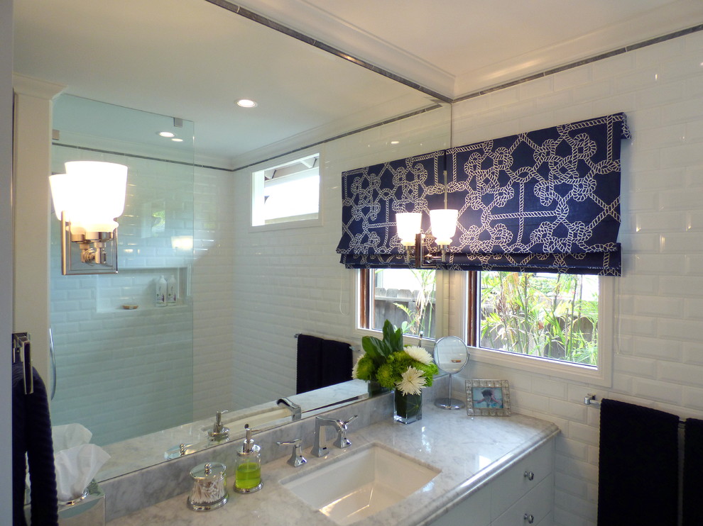 Photo of a small classic shower room bathroom in Los Angeles with a submerged sink, flat-panel cabinets, white cabinets, marble worktops, an alcove shower, a one-piece toilet, white tiles, metro tiles, blue walls and porcelain flooring.