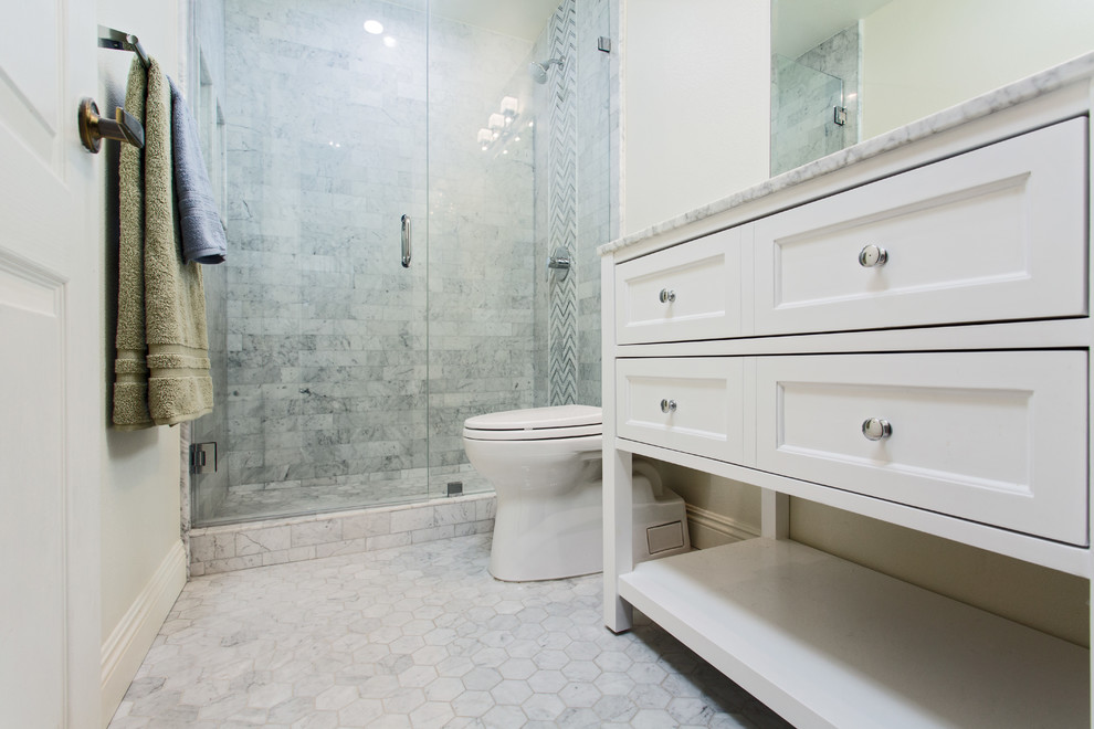Inredning av ett klassiskt litet badrum med dusch, med skåp i shakerstil, vita skåp, en dusch i en alkov, en toalettstol med hel cisternkåpa, svart och vit kakel, marmorkakel, vita väggar, marmorgolv, ett undermonterad handfat, marmorbänkskiva, flerfärgat golv och dusch med gångjärnsdörr