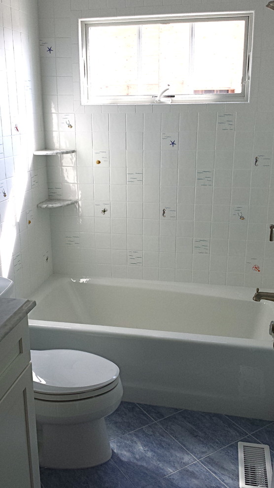 Immagine di una stanza da bagno stile marino con piastrelle bianche, piastrelle in gres porcellanato, top in marmo, vasca ad alcova e WC monopezzo