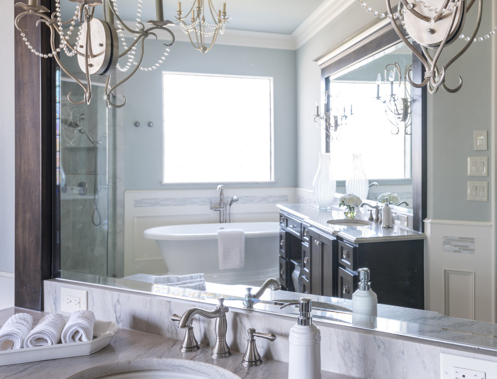 Inspiration for a large traditional ensuite bathroom in Dallas with dark wood cabinets, a freestanding bath, a built-in shower, grey walls, porcelain flooring, a submerged sink, shaker cabinets, grey tiles, ceramic tiles, marble worktops, white floors and a hinged door.