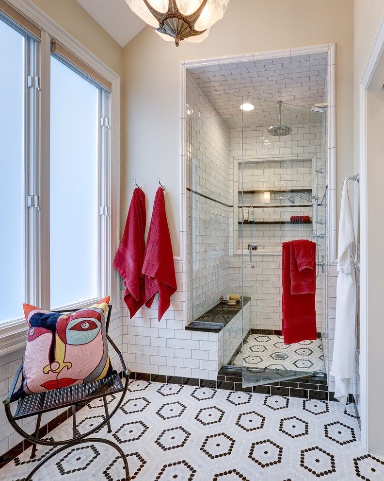 Klassisk inredning av ett en-suite badrum, med vit kakel, tunnelbanekakel, mosaikgolv, en dusch i en alkov, beige väggar, flerfärgat golv och dusch med gångjärnsdörr