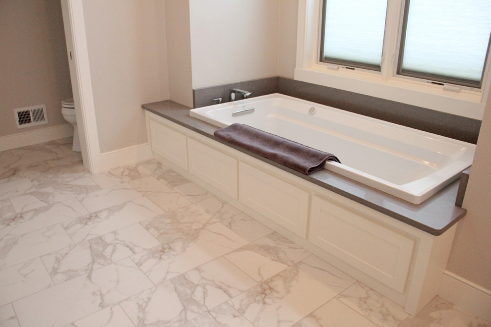Immagine di una grande stanza da bagno padronale design con WC monopezzo, piastrelle bianche, pareti beige, ante bianche, vasca da incasso e pavimento beige
