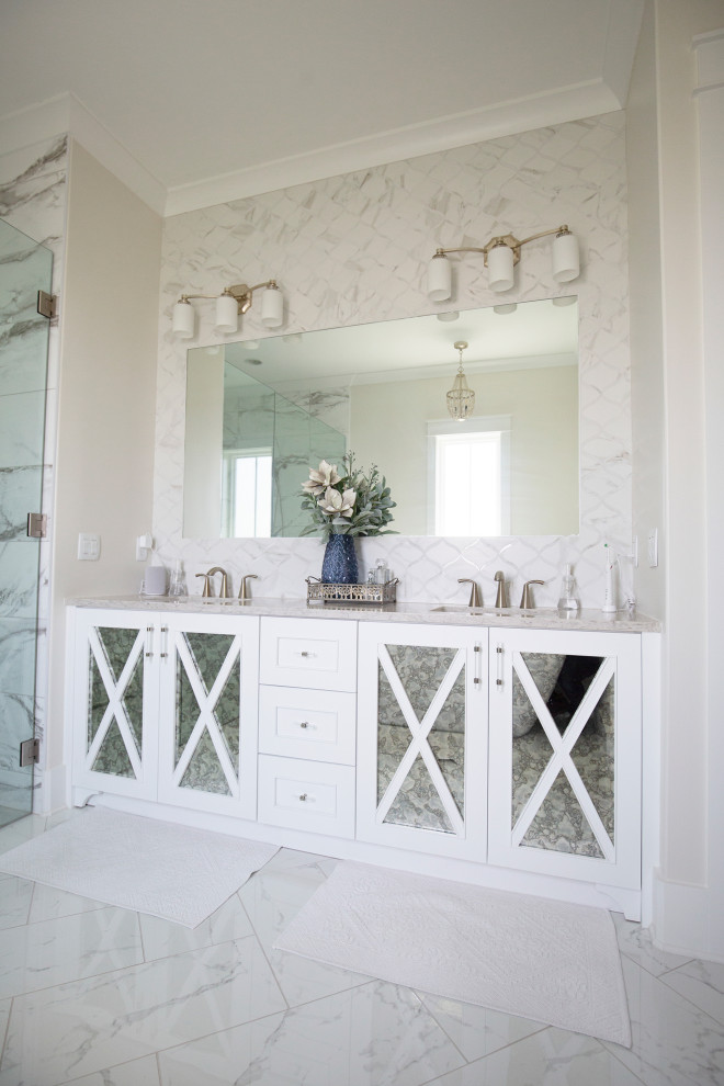 Идея дизайна: большая главная ванная комната в стиле неоклассика (современная классика) с фасадами в стиле шейкер, белыми фасадами, отдельно стоящей ванной, двойным душем, бежевыми стенами, мраморным полом, накладной раковиной, мраморной столешницей, белым полом, душем с распашными дверями, бежевой столешницей, тумбой под две раковины, встроенной тумбой, многоуровневым потолком и обоями на стенах