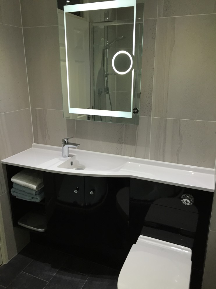 Modern bathroom in Essex with black cabinets, a corner shower and grey tiles.