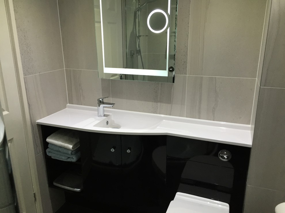 Inspiration for a modern bathroom in Essex with black cabinets, a corner shower and grey tiles.