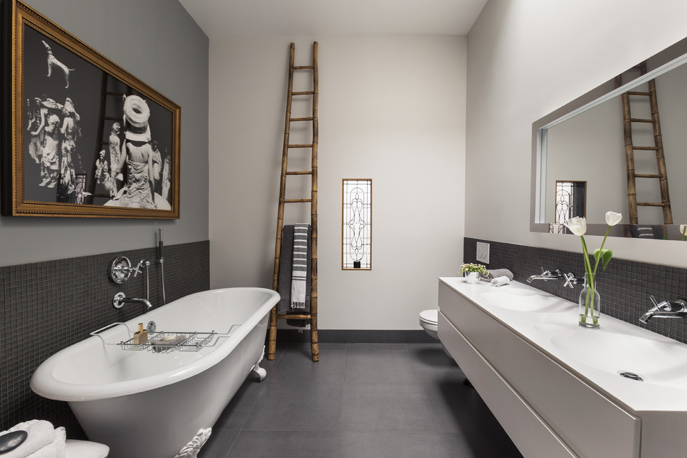 Idéer för funkis en-suite badrum, med släta luckor, grå skåp, ett badkar med tassar, en vägghängd toalettstol, grå väggar och ett integrerad handfat