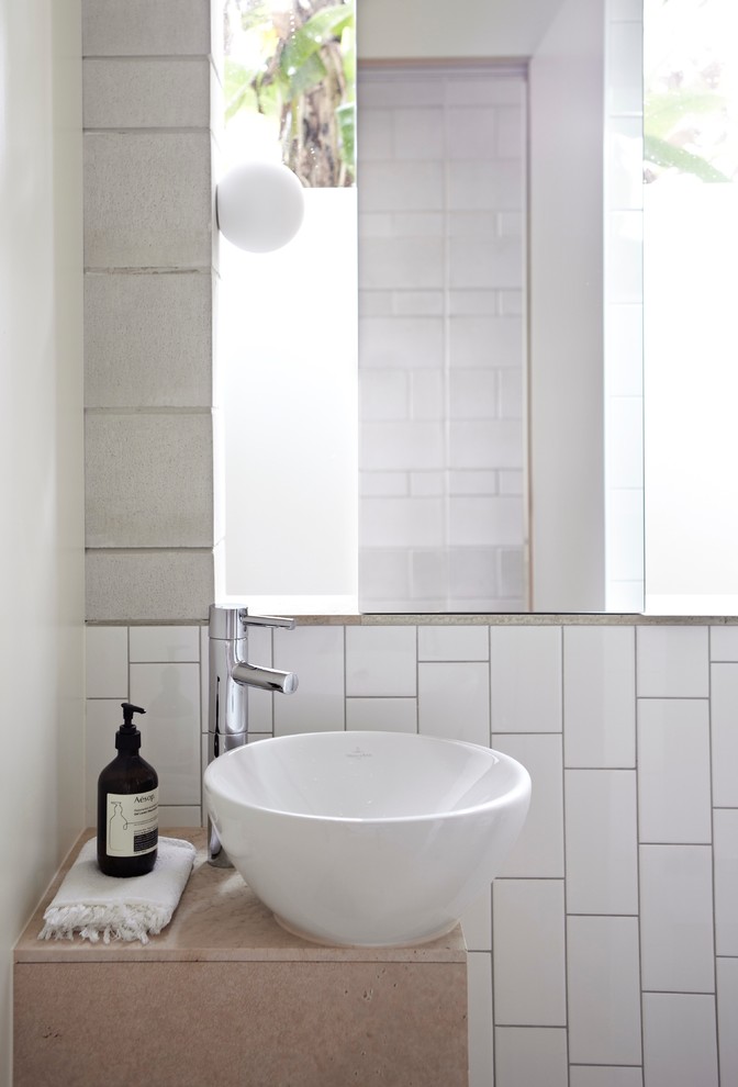 Ispirazione per una stanza da bagno minimal con lavabo a bacinella, piastrelle bianche e pareti bianche