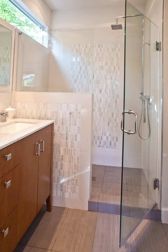 Immagine di una stanza da bagno con doccia moderna di medie dimensioni con ante lisce, ante in legno scuro, piastrelle grigie, piastrelle di marmo, pareti bianche, pavimento in gres porcellanato, lavabo sottopiano, pavimento beige e porta doccia a battente