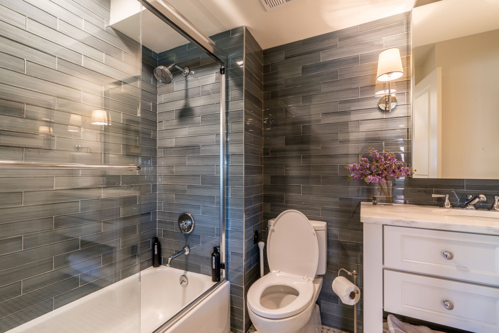 Klassisk inredning av ett vit vitt badrum, med luckor med infälld panel, vita skåp, ett badkar i en alkov, en dusch/badkar-kombination, en toalettstol med separat cisternkåpa, ett undermonterad handfat och dusch med skjutdörr