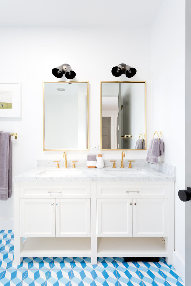 Modelo de cuarto de baño tradicional renovado con puertas de armario blancas, paredes blancas, suelo de azulejos de cemento, lavabo bajoencimera, suelo azul y armarios con paneles empotrados