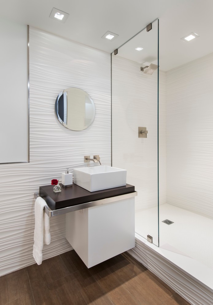 Mid-sized trendy 3/4 white tile and porcelain tile porcelain tile doorless shower photo in Boston with flat-panel cabinets, white cabinets, a one-piece toilet, white walls, a vessel sink and wood countertops
