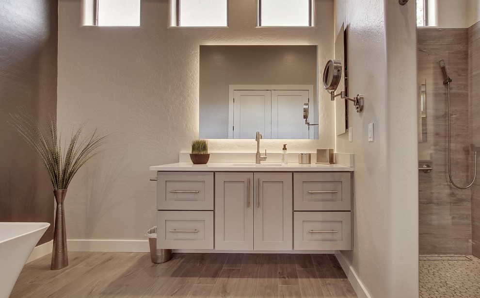 Large transitional master gray tile and porcelain tile porcelain tile and brown floor bathroom photo in Phoenix with shaker cabinets, gray cabinets, a two-piece toilet, gray walls, an undermount sink, quartz countertops, a hinged shower door and white countertops