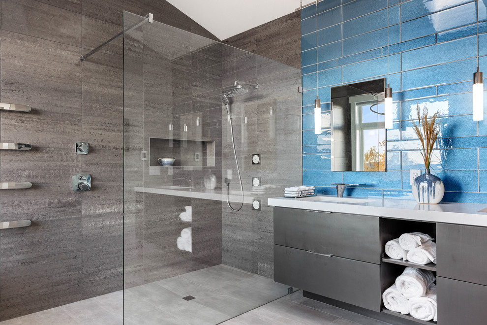 Photo of a large contemporary ensuite bathroom in Seattle with flat-panel cabinets, black cabinets, a freestanding bath, a built-in shower, grey tiles, porcelain tiles, grey walls, porcelain flooring, a submerged sink, engineered stone worktops, grey floors, an open shower and white worktops.
