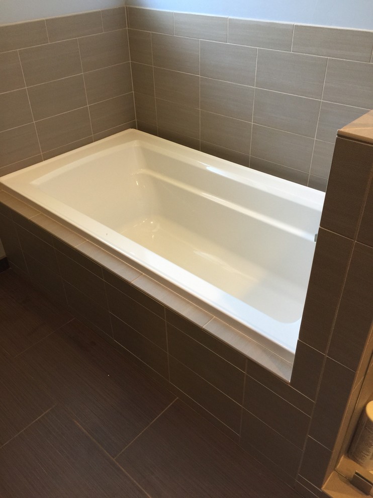 На фото: главная ванная комната среднего размера в стиле модернизм с ванной в нише, коричневой плиткой, керамогранитной плиткой и полом из керамогранита с