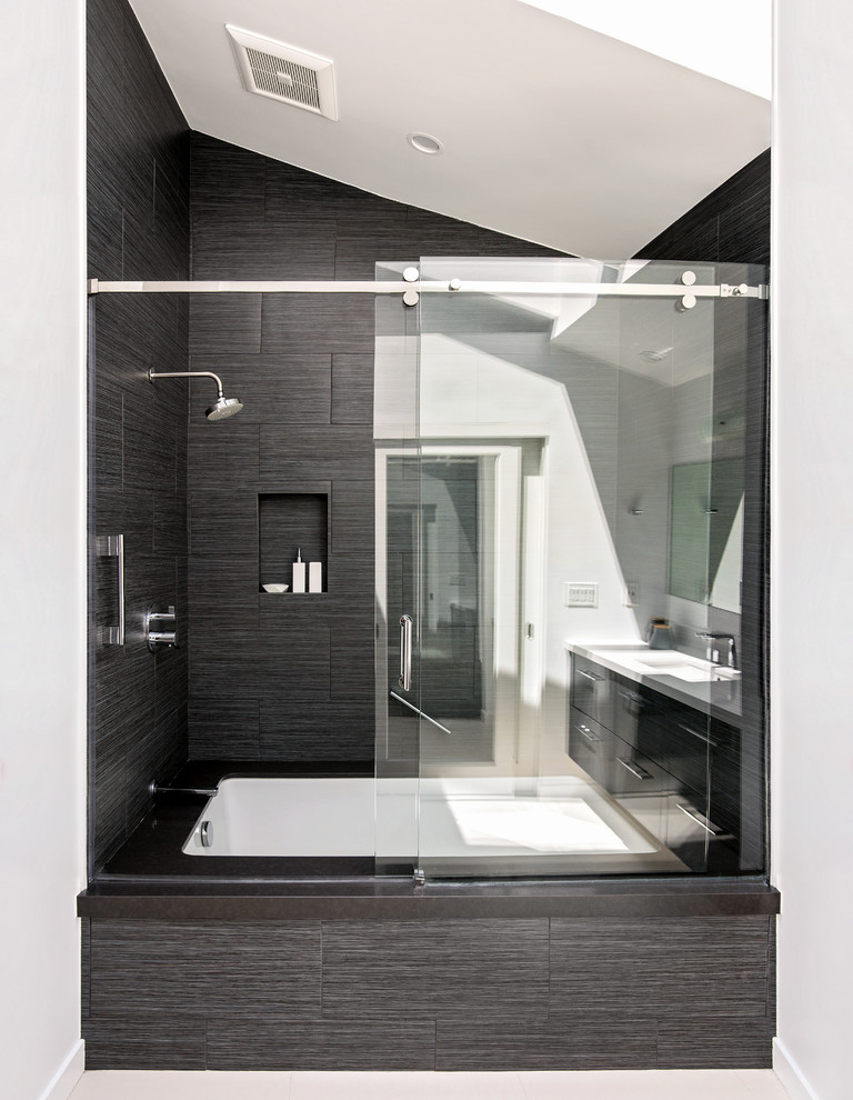Example of a mid-sized minimalist master black tile and ceramic tile ceramic tile tub/shower combo design in Orange County with flat-panel cabinets, gray cabinets, an undermount tub, a one-piece toilet, white walls, an undermount sink and quartz countertops