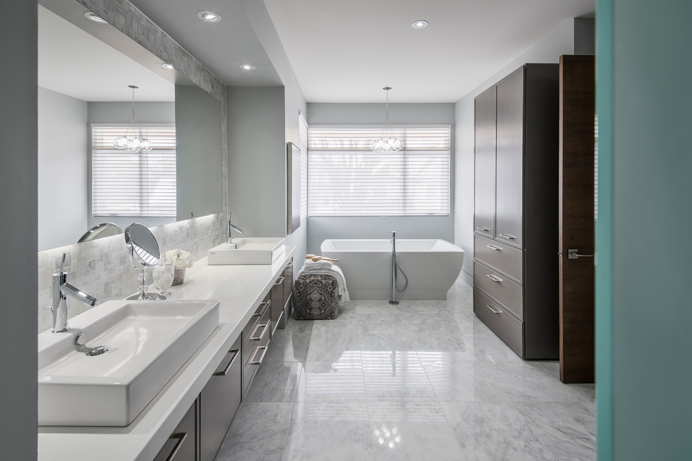 Immagine di una stanza da bagno design con ante lisce, ante marroni, vasca freestanding, piastrelle grigie, pareti grigie, lavabo a bacinella e pavimento grigio