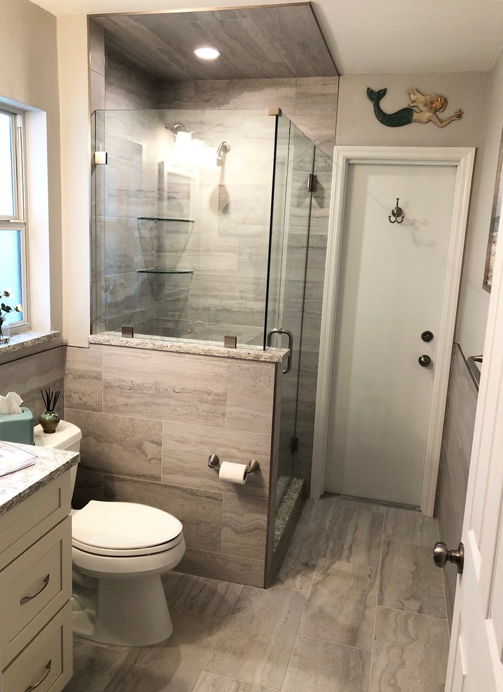 Idéer för små vintage flerfärgat badrum med dusch, med skåp i shakerstil, grå skåp, en dusch i en alkov, en toalettstol med hel cisternkåpa, grå kakel, porslinskakel, grå väggar, klinkergolv i porslin, ett undermonterad handfat, granitbänkskiva, grått golv och dusch med gångjärnsdörr