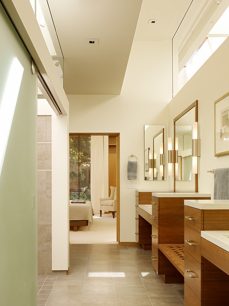 На фото: большая главная ванная комната в современном стиле с плоскими фасадами, фасадами цвета дерева среднего тона, столешницей из искусственного камня, душем в нише, полом из керамической плитки, врезной раковиной и серой плиткой с