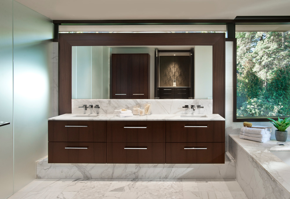 Пример оригинального дизайна: главная ванная комната в современном стиле с плоскими фасадами, темными деревянными фасадами, белой плиткой, мраморным полом, врезной раковиной, мраморной столешницей, полновстраиваемой ванной и душем без бортиков