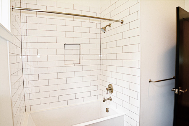 Medium sized classic family bathroom in Boise with a shower/bath combination, white tiles, ceramic tiles, white walls, shaker cabinets, black cabinets, an alcove bath, a one-piece toilet, medium hardwood flooring, a submerged sink and engineered stone worktops.