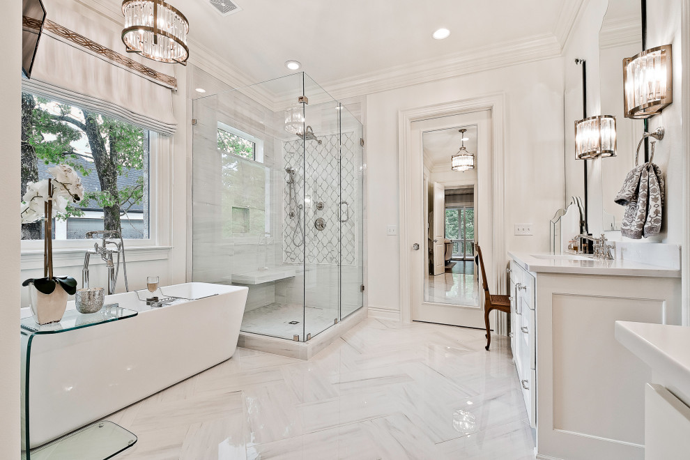 На фото: огромная главная ванная комната в стиле неоклассика (современная классика) с белыми фасадами, отдельно стоящей ванной, раздельным унитазом, белой плиткой, керамогранитной плиткой, белыми стенами, полом из керамогранита, врезной раковиной, столешницей из кварцита, серым полом, душем с распашными дверями, белой столешницей, сиденьем для душа, тумбой под две раковины и встроенной тумбой