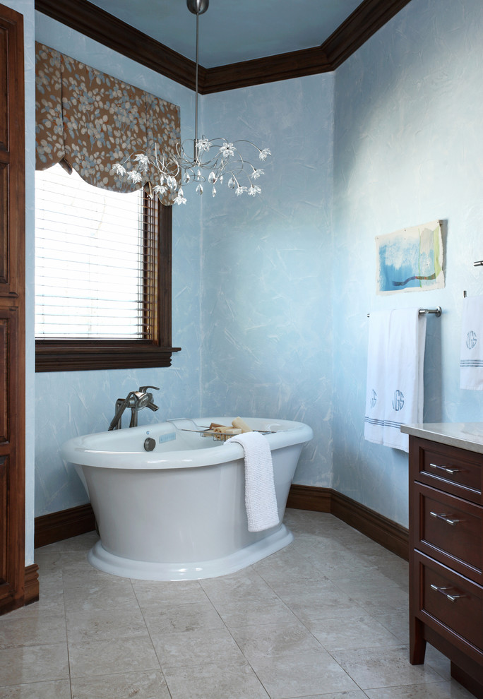 Esempio di una stanza da bagno padronale classica con lavabo a bacinella, ante con riquadro incassato, ante in legno scuro, top in granito, vasca freestanding, piastrelle marroni, piastrelle di vetro, pareti blu e pavimento in gres porcellanato